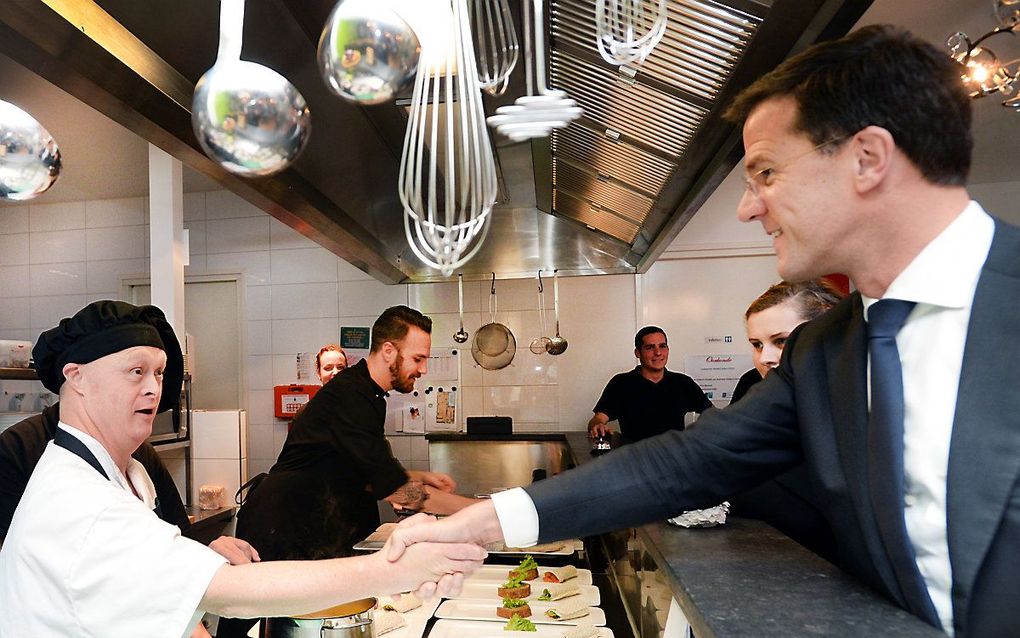 Premier Mark Rutte groet een werknemer van een restaurant in Almelo dat wordt gerund door mensen met een licht verstandelijke beperking. beeld ANP, Piroschka van de Wouw