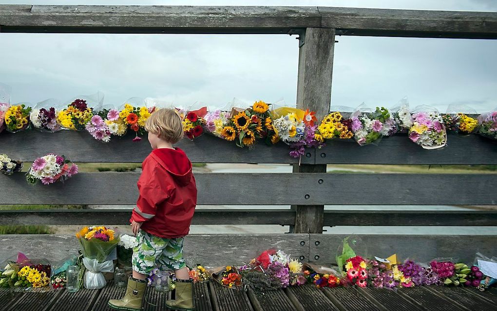 Een jongetje loopt langs bloemen die zijn neergelegd voor de slachtoffers van de vliegtuigcrash in Shoreham, Engeland. beeld EPA