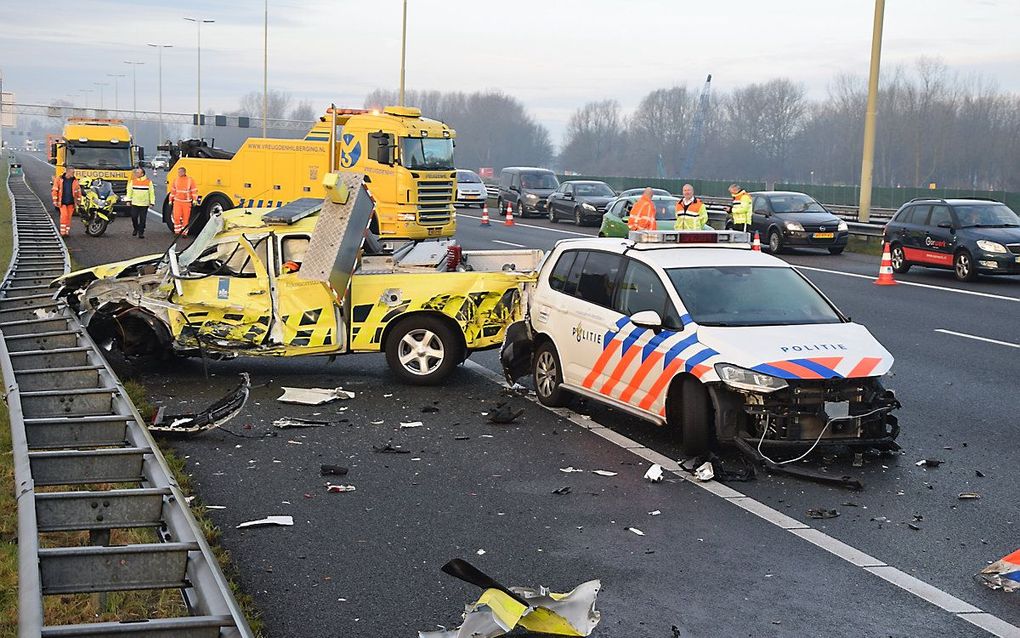 Schade aan een politieauto en een voertuig van een weginspecteur nadat een vrachtwagen ze aanreed. beeld ANP