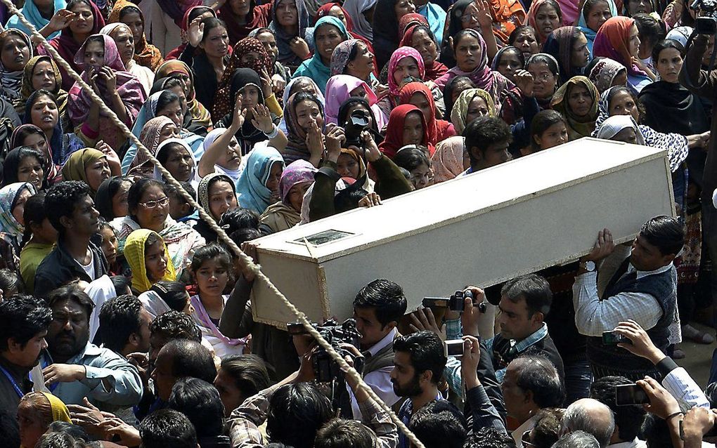 Pakistaanse christenen dragen een kist met daarin een slachtoffer van de zelfmoordaanslag op twee kerken in maart 2015 in Lahore, Pakistan. beeld AFP, Arif Ali