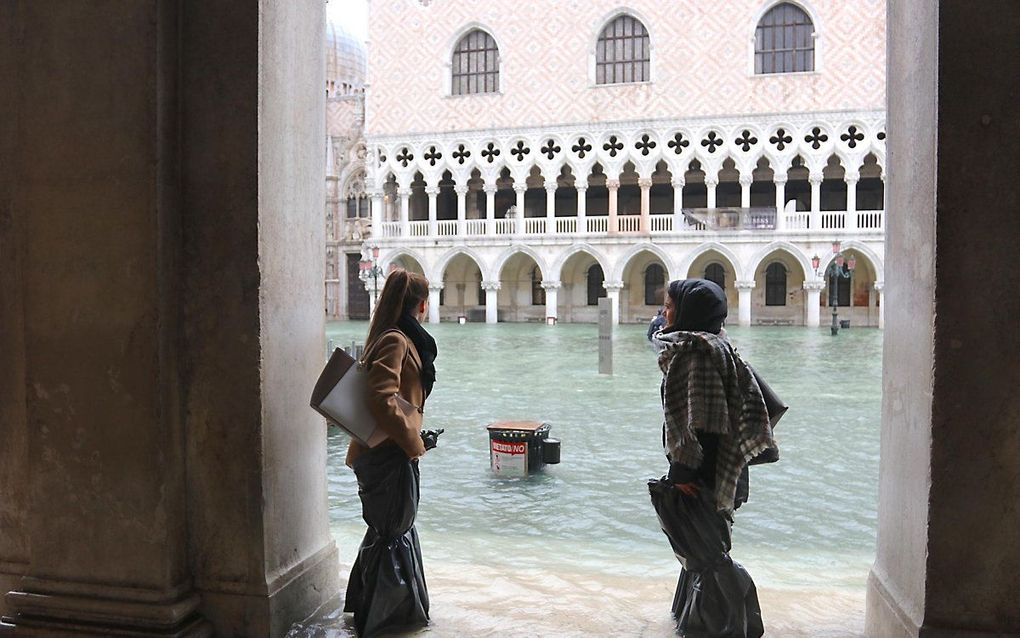 Twee vrouwen bij het overstroomde San Marcoplein in Venetië. beeld EPA