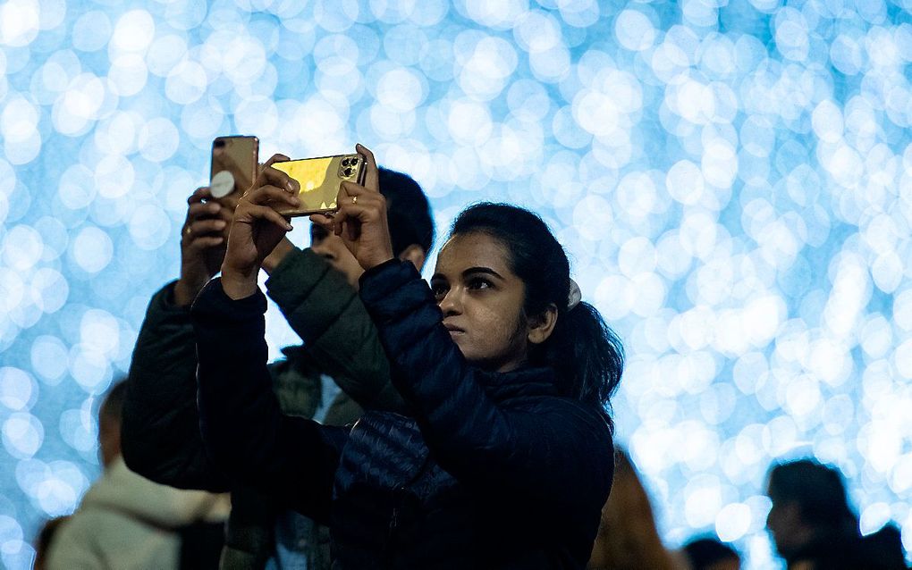 Een vrouw maakt een foto met haar smartphone. beeld AFP