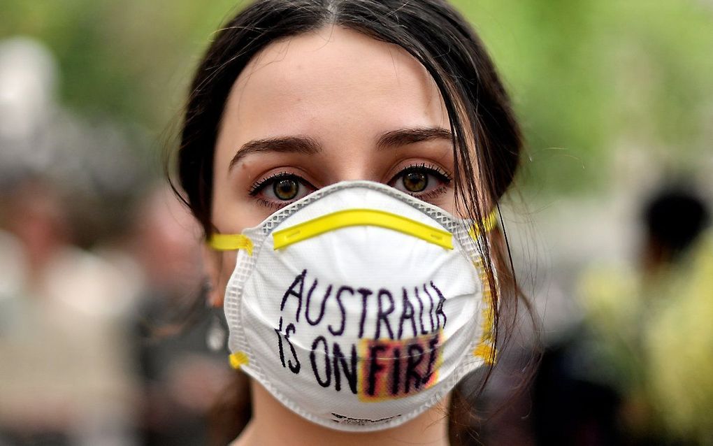 Een demonstrante demonstreert voor aanpak van klimaatverandering nu Australie getroffen wordt door bosbranden die voor smog zorgen tot in Sydney. beeld AFP