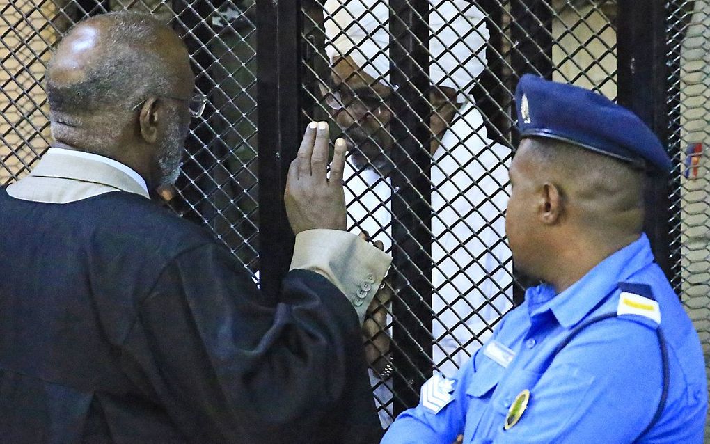 Omar al Bashir achter de tralies tijdens een zitting van de rechtbank in Khartoum eerder deze maand. beeld AFP