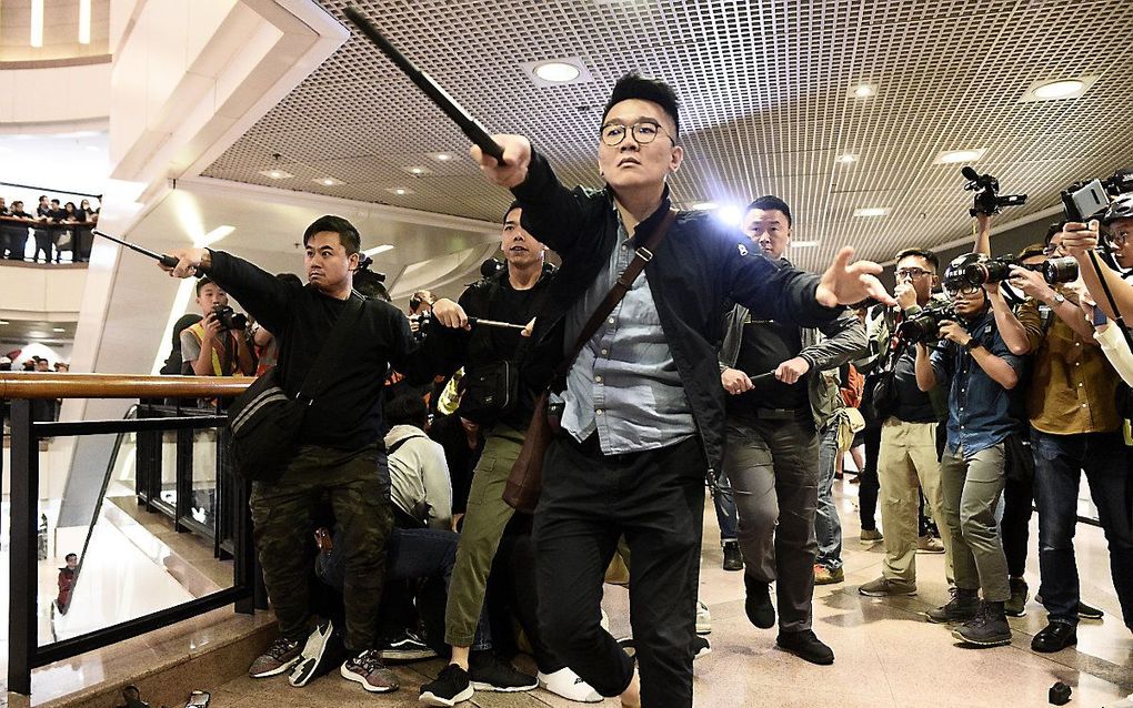 Politieagenten in burger botsen met demonstranten in een winkelcentrum in Hongkong. beeld AFP