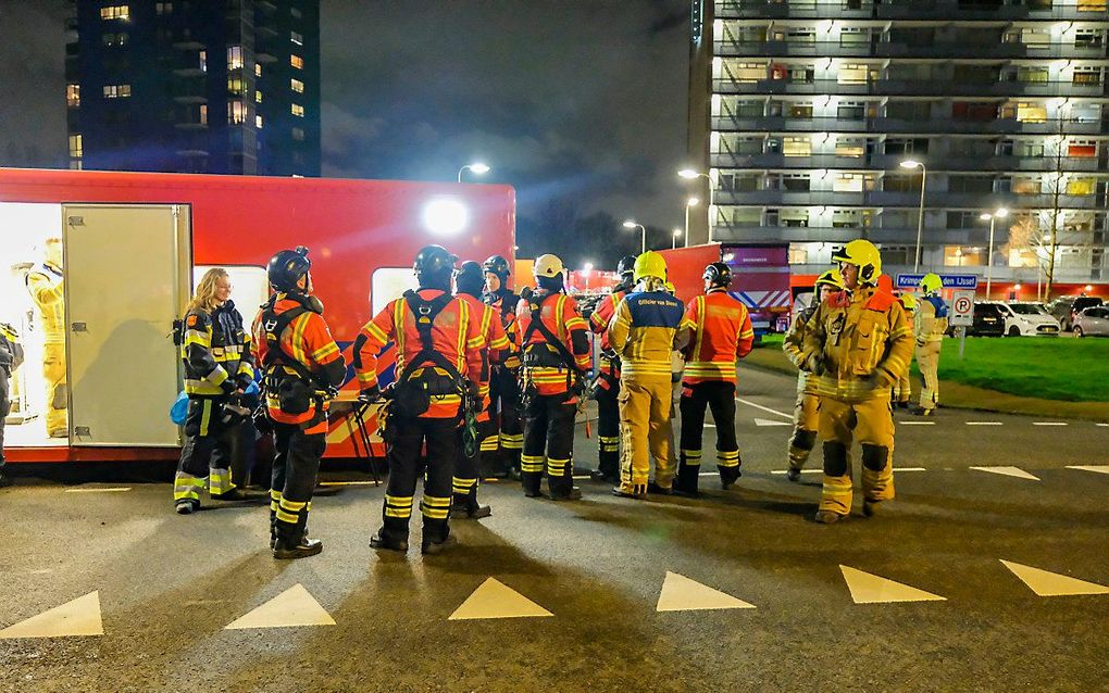 Brandweermannen bij de flats. beeld ANP