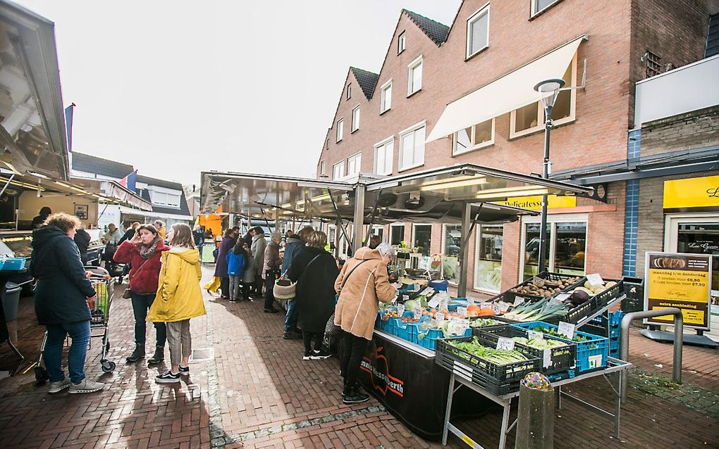 Inwoners van Loon op Zand doen boodschappen op de markt, een dag nadat bekend is geworden dat een plaatsgenoot in het Elisabeth TweeSteden Ziekenhuis is opgenomen met coronavirus Covid-19.. beeld ANP