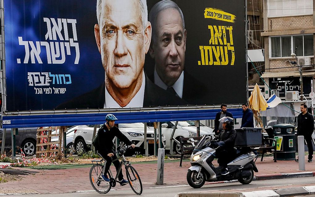 Een verkiezingsposter in Ramat Gan in Israël, met links Benny Gantz en rechts Benjamin Netanyahu. beeld AFP