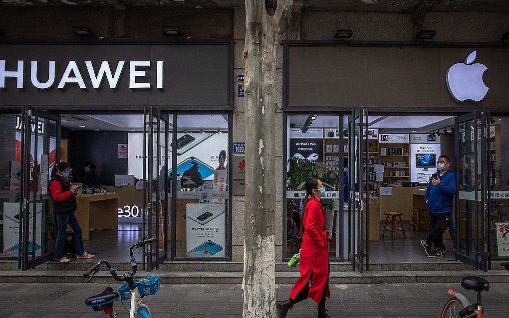 Een pand van Apple en Huawei staan naast elkaar in de Chinese stad Wuhan. beeld EPA