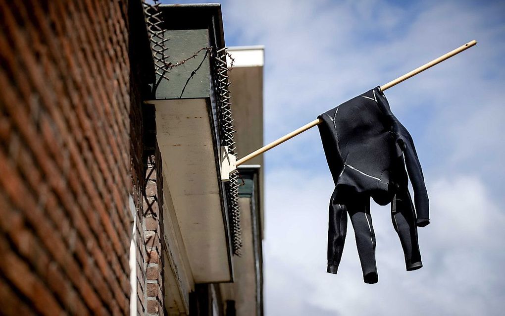 Een wetsuit hangt halfstok in Scheveningen. beeld ANP