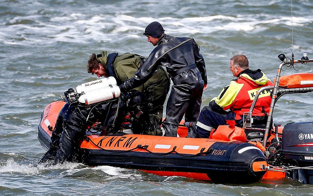 Een duiker van Defensie wordt uit het water gehaald. Defensie zoekt mee naar de stoffelijke resten van het vijfde slachtoffer van het surfdrama. beeld ANP