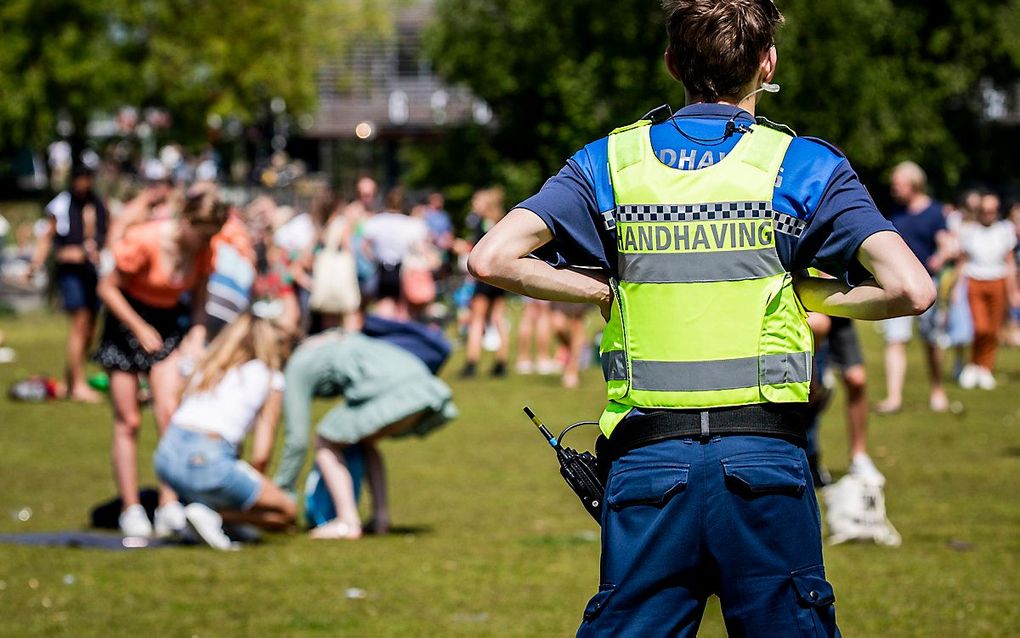 Handhavers en politie ontruimen Park Somerlust vanwege de te grote drukte. beeld ANP