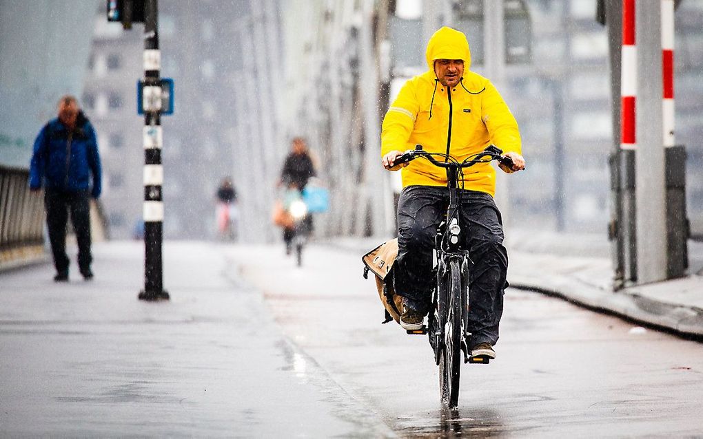 Een fietser trotseert de regen op de Erasmusbrug. beeld ANP