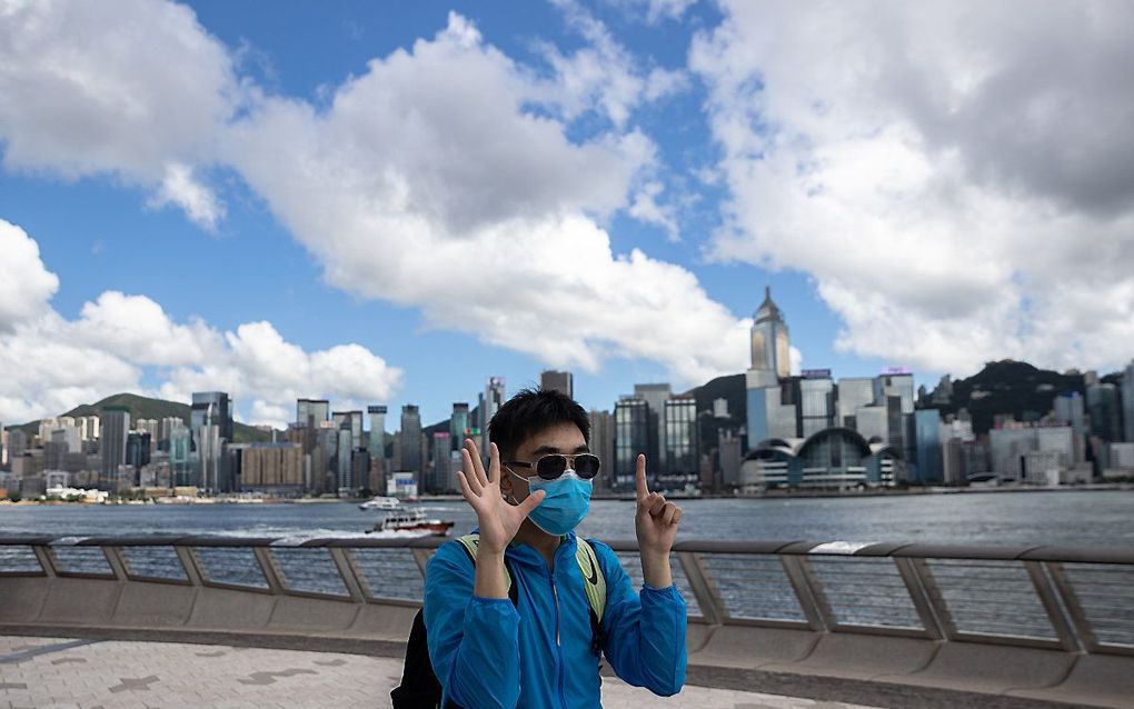 Een activist in Hong Kong maakt het 'vijf eisen, en niet eentje minder'-gebaar. Een van de eisen van de demonstranten is het intrekken van de nieuwe veiligheidswet. beeld EPA