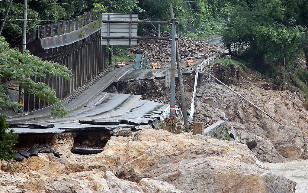 Een weg is verwoest door de overstromingen bij de Kuma-rivier in Ashikita, Kumamoto-prefectuur, Japan, 6 juli 2020.  Beeld EPA/JIJI PRESS JAPAN