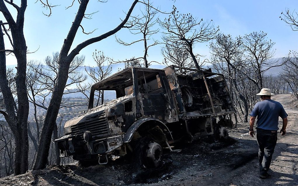 Een geblakerde brandweerauto bij Athikia, Griekenland. beeld EPA