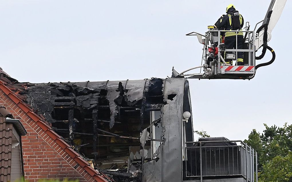 Reddingsdiensten in actie nadat een ultralight vliegtuigje op een huis in Wesel, Duitsland, neerstortte. Beeld EPA / Sascha Steinbach