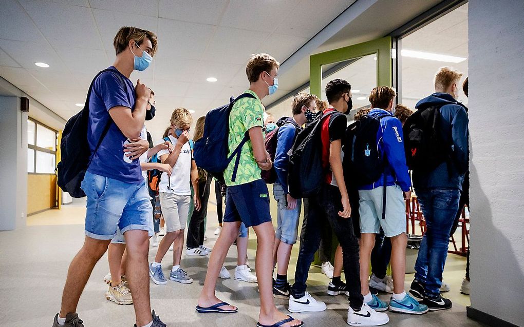 Leerlingen van het Mendel College in Haarlem dragen een mondkapje. Vakbond CNV Onderwijs vindt dat scholen dezelfde coronamaatregelen moeten nemen. beeld ANP, Robin van Lonkhuijsen