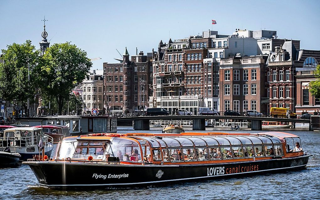 Toeristen op een rondvaartboot in Amsterdam. beeld ANP, RAMON VAN FLYMEN