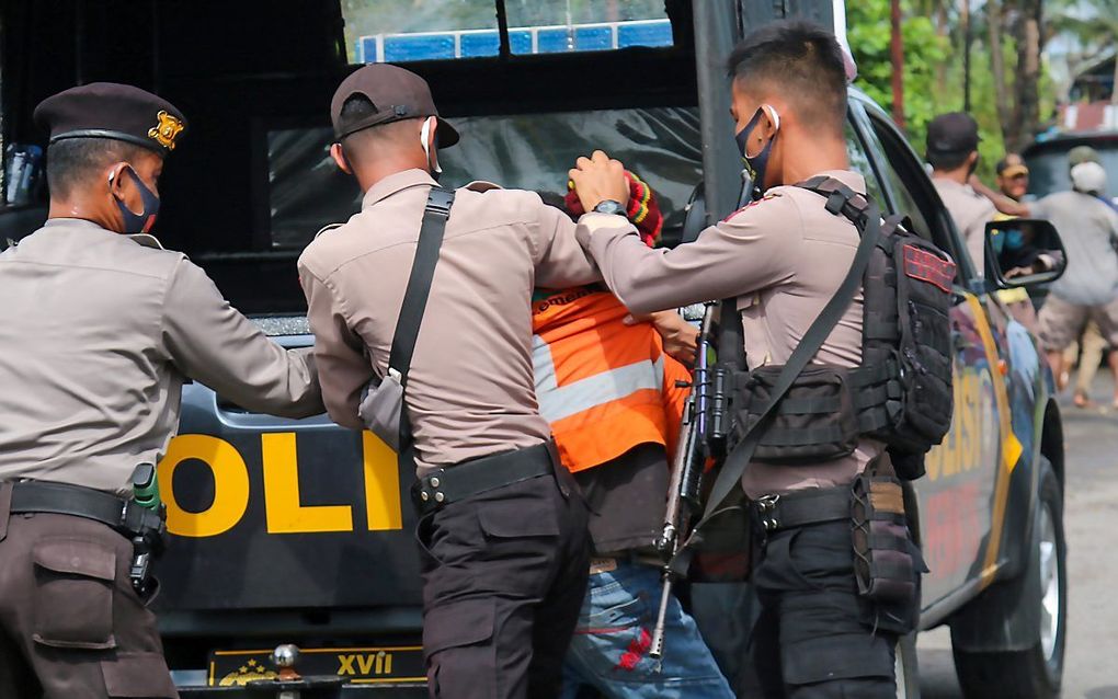 Een activist wordt gearresteerd in Papoea. In de regio zijn de laatste maanden grote spanningen tussen separatistische groepen en veiligheidstroepen. Beeld AFP, Sevianto Pakiding