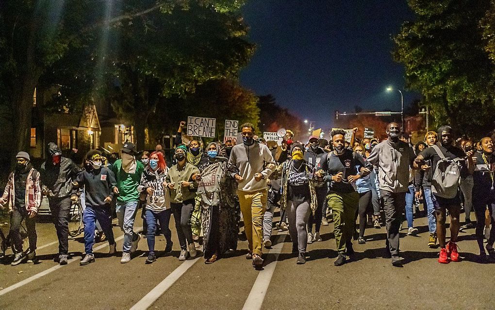 Demonstranten in Minneapolis lopen arm in arm. beeld AFP, Kerem Yucel