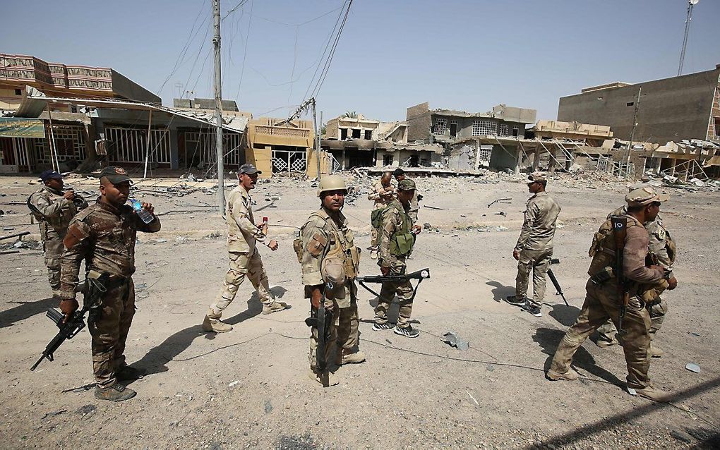 Irakese politieagenten patrouilleren door de straten van Fallujah, voormalig IS-bolwerk. beeld AFP