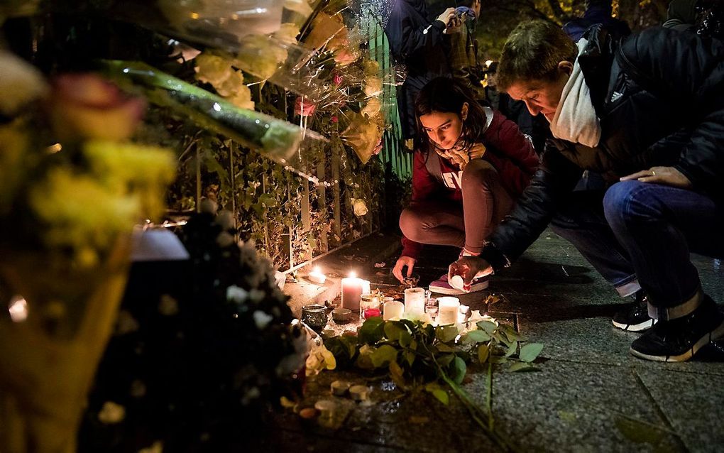 Mensen leggen bloemen in de buurt van de Parijse concertzaal Bataclan, waar op 13 november 2015 negentig mensen vermoord werden. beeld ANP