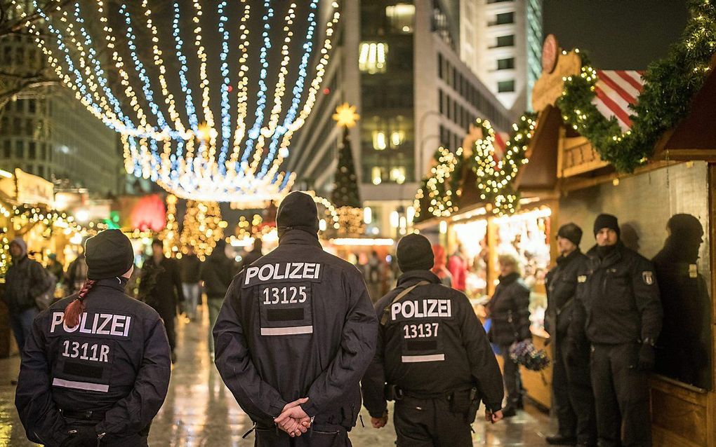 Politieagenten lopen over de heropende kerstmarkt in Berlijn, drie dagen na de aanslag op 19 december 2016. beeld EPA