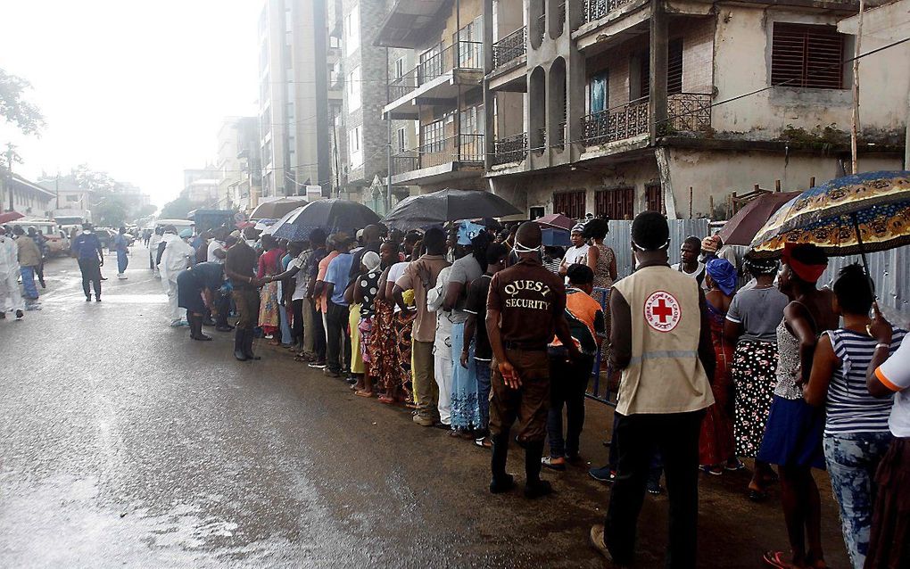 Rijen voor een ziekenhuis in Freetown, waar mensen familieleden willen bezoeken. beeld AFP