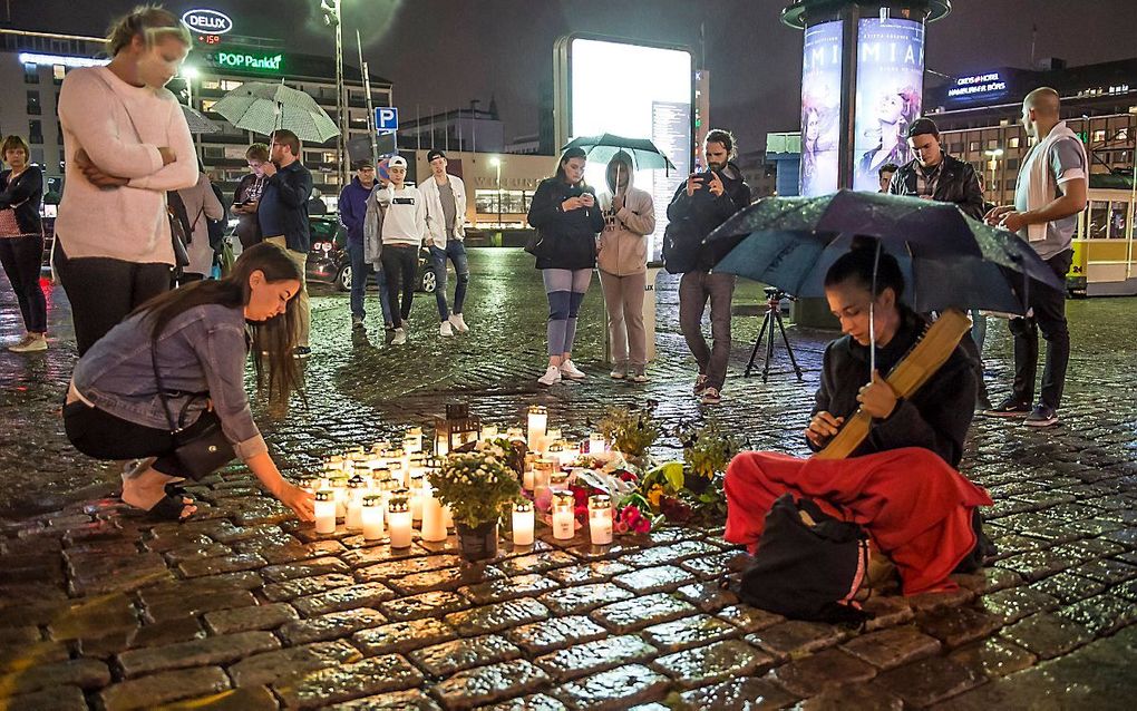 Inwoners van Turku herdenken de slachtoffers van de steekpartij. beeld EPA