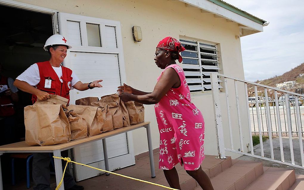 In een colonne van zo’n tien voertuigen, reden legervoertuigen en personenauto’s donderdag over Sint-Maarten om voedsel te brengen in de wijken waar dat het hardste nodig is.  beeld ANP