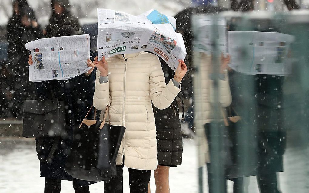 In Zuid-Korea beschermen mensen hun gezicht voor een sneeuwstorm. beeld EPA