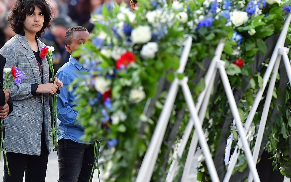 Kinderen leggen bloemen tijdens de nationale dodenherdenking. beeld ANP