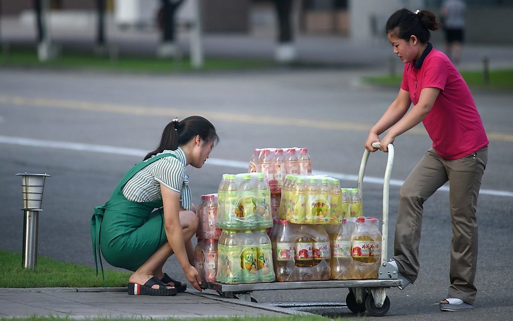 Noord-Koreanen in de weer met een kar frisdrank in Pyongyang, de hoofdstad van Noord-Korea. beeld AFP