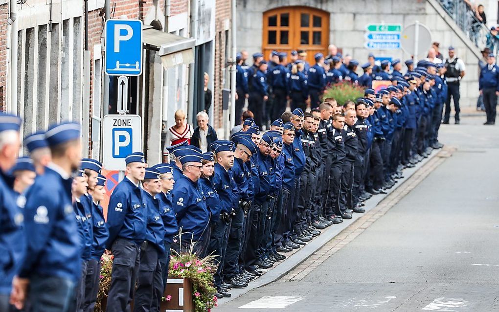 Agenten staan langs de weg als de rouwstoet van de doodgeschoten politieman passeert. beeld EPA