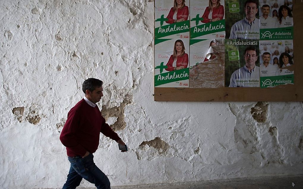 Een man passeert affiches van politieke partijen in Setenil de las Bodegas. beeld AFP