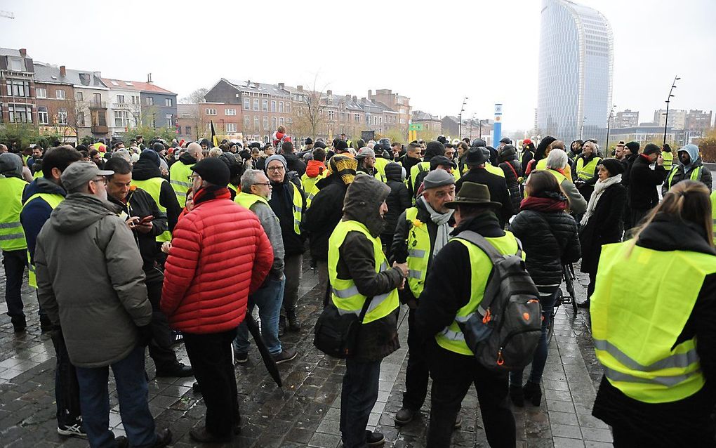 Gele hesjes zaterdag in Luik herdenken de omgekomen demonstrant. beeld AFP