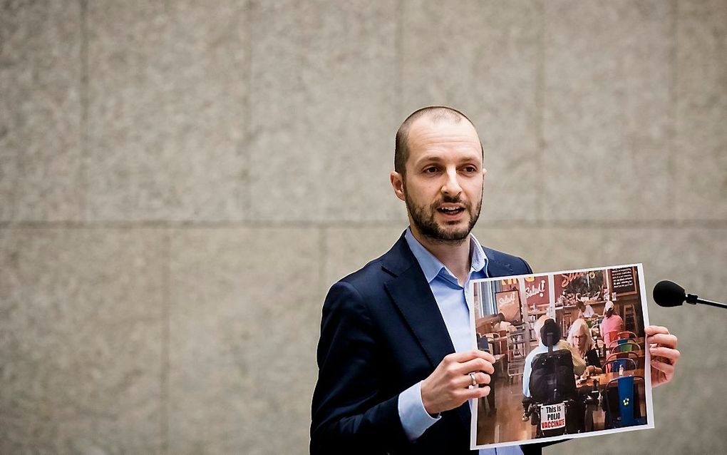 Maarten Heijink (SP) laat een foto zien van iemand met polio tijdens het Tweede Kamerdebat over vaccinatie in Nederland.  beeld ANP