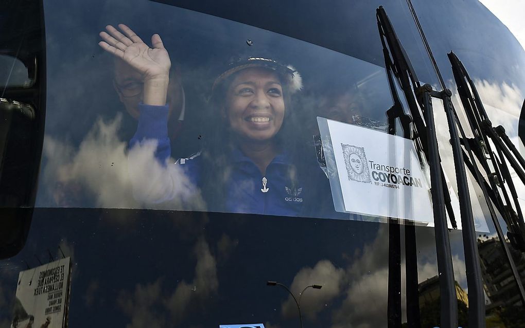 Een lid van de Venezolaanse oppositie in een bus die naar de Colombiaanse grens rijdt om Amerikaanse hulpgoederen te halen. beeld AFP