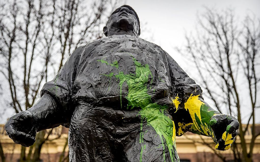 De Dokwerker is beklad met gele en groene verf, de kleuren van de voetbalclub ADO Den Haag. beeld ANP