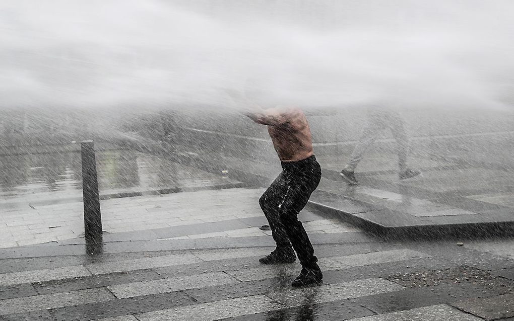 Demonstrant wordt van de sokken gespoten in Parijs. beeld AFP