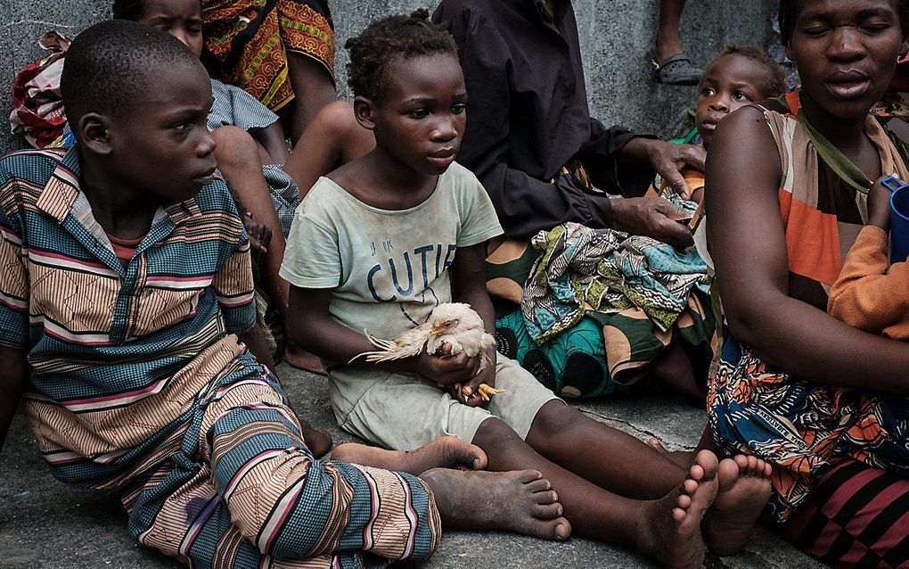 Emilia Joao (m.) houdt een kuiken vast in een school die gebruikt wordt als evacuatiecentrum. beeld AFP