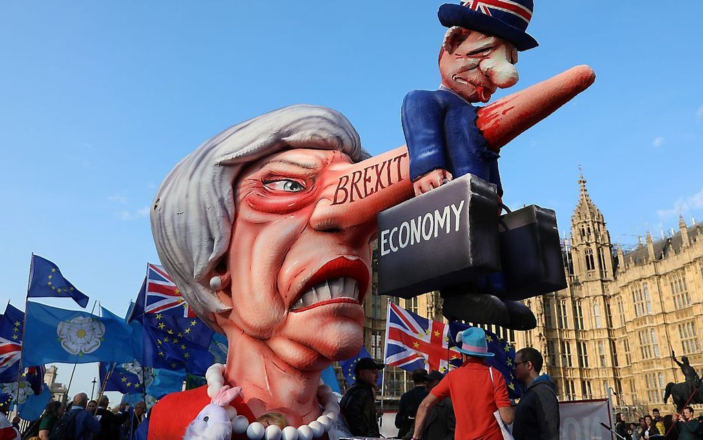 Anti-brexitdemonstranten demonstreren met een karikatuur van May, afgelopen april. beeld AFP