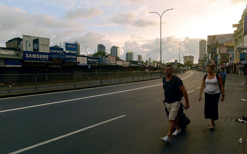 Toeristen op straat in Colombo. beeld AFP