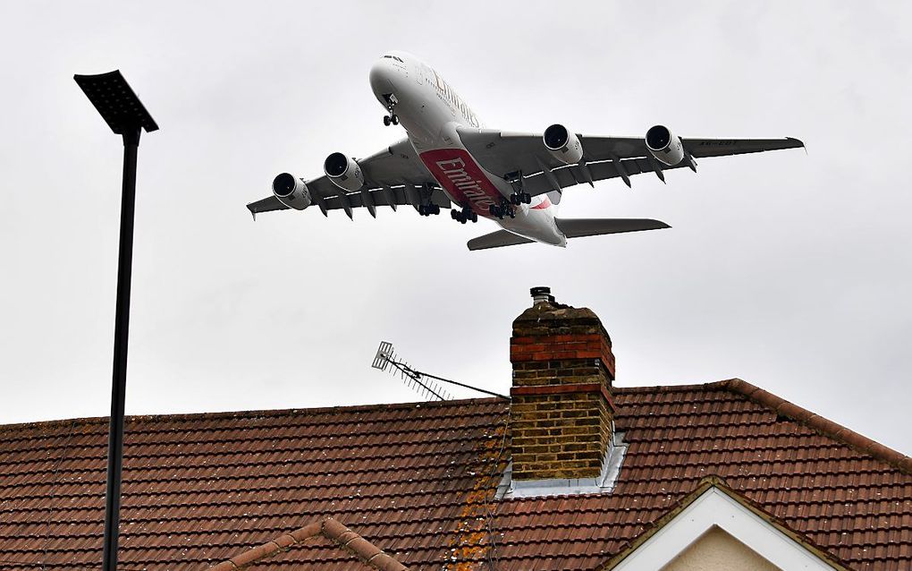 Een vliegtuig vliegt over huizen in de buurt van Heathrow Airport. beeld AFP