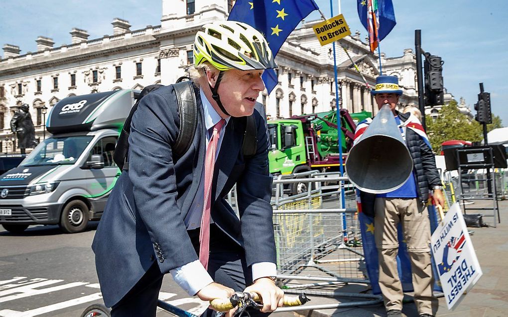 Boris Johnson op een fiets in Londen. beeld AFP