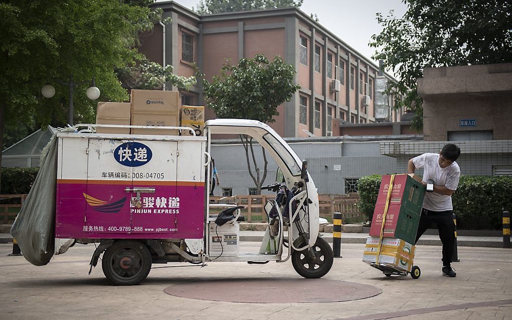 Een pakketbezorger in Beijing. beeld AFP