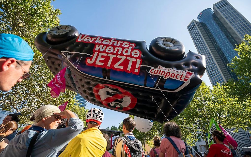 Protestanten met een opblaasbare auto bij de demonstratie in Frankfurt. beeld EPA