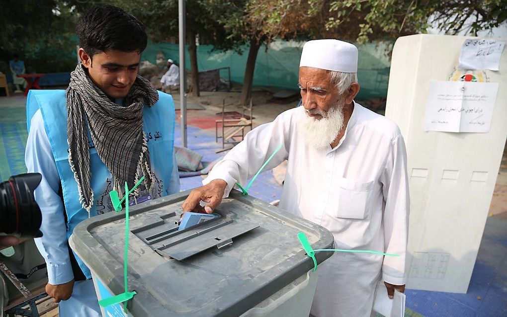 Een Afghaanse man levert zijn stembiljet in in Jalalabad, Afghanistan. beeld EPA