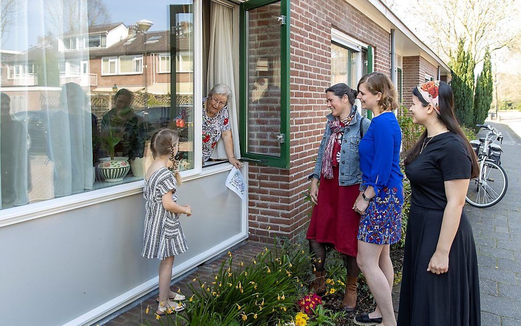 De 86-jarige Cornelia Smit-Ligtenberg uit Vinkeveen krijgt raambezoek van haar 5-jarige achterkleindochter Avia (5), schoondochter Christine (50) en kleindochters Kyra (23) en Sara-Maria (24, rechts op de foto) beeld RD, Henk Visscher